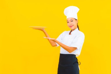 Sarı izole edilmiş plakalı güzel Asyalı şef kadın portresi.