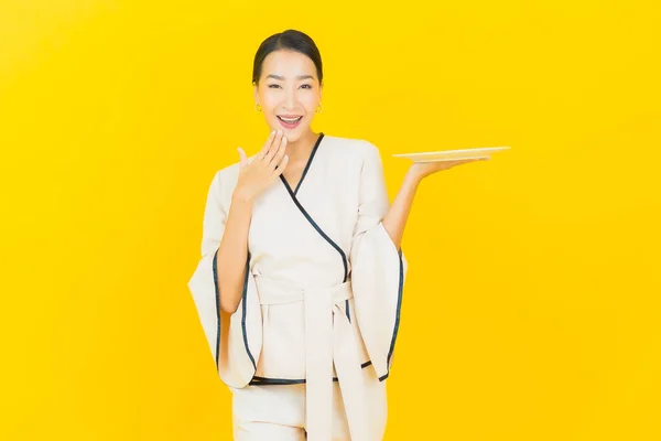Sarı Arka Planda Boş Tabak Tabağı Olan Güzel Genç Asyalı — Stok fotoğraf