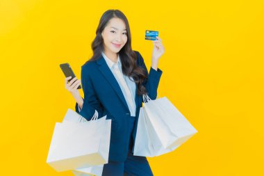 Portre güzel Asyalı kadın tebessümü ile renk arka planında alışveriş torbası