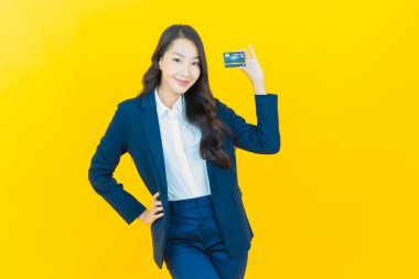 Güzel bir Asyalı kadının portresi. Renkli kredi kartıyla gülüyor.