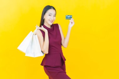 Portre güzel Asyalı kadın tebessümü ile renk arka planında alışveriş torbası