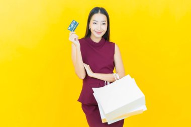 Portre güzel Asyalı kadın tebessümü ile renk arka planında alışveriş torbası