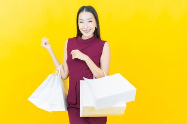 Portre güzel Asyalı kadın tebessümü ile renk arka planında alışveriş torbası