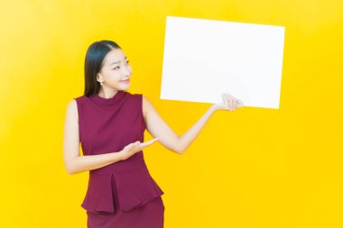 Renkli arka planda boş beyaz ilan panosu olan güzel Asyalı kadın portresi