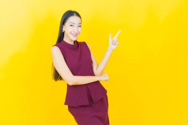 Portre güzel Asyalı kadın gülümsüyor. Renkli arka planda hareket var.