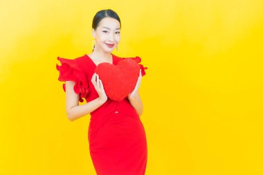 Renk arka planında kırmızı zarflı güzel Asyalı kadın portresi.