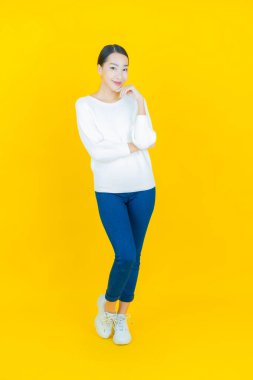 Portre güzel Asyalı kadın gülümsüyor. Renkli arka planda hareket var.