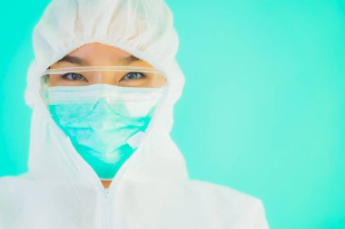Güzel, genç Asyalı doktor kadın portre. Koronavirüsten ya da mavi arka planda kovid19 'dan korunmak için ppe ya da kişisel koruyucu ekipman takıyor.