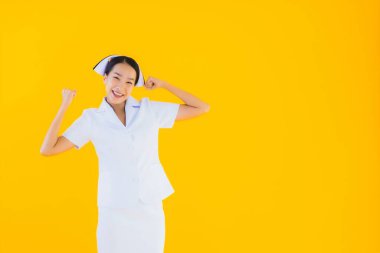 Güzel Asyalı genç Taylandlı hemşirenin portresi klinikteki ve hastanedeki hastalar için sarı izole edilmiş arka planda birçok eylem çalışmasında yer alıyor.