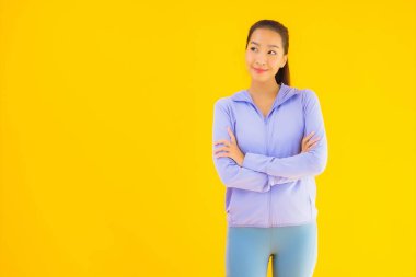Sarı izole edilmiş arka planda spor giysili güzel Asyalı kadın portresi egzersize hazır.
