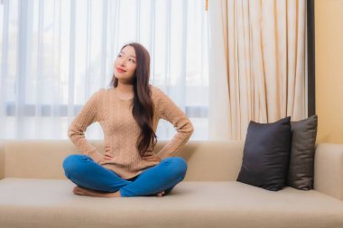 Güzel bir Asyalı kadın portresi rahatla. Gülümse. Yatak odasının iç dekorasyonunda mutlu ol.