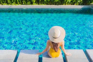 Güzel bir Asyalı kadın portresi. Rahatlayın. Keyifli bir tatil için oteldeki yüzme havuzunda mutlu bir gülümseme.