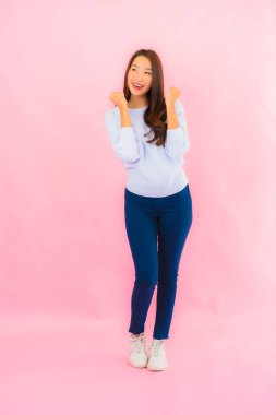 Portrait beautiful young asian woman smile with action on pink isolated background