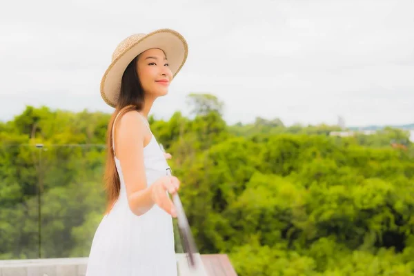 年轻美丽的亚洲女子在有海景背景的阳台上快乐地笑着 — 图库照片