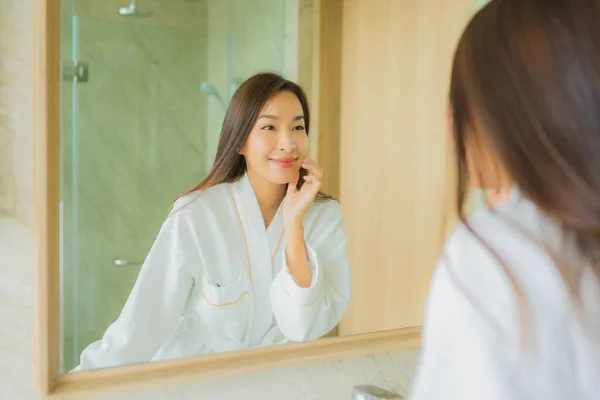 ポートレート美しい若いアジア人女性チェックアップ顔でバスルーム内装 — ストック写真