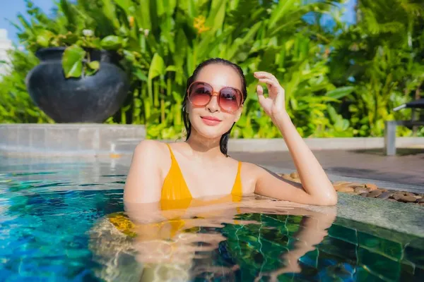 ポートレート美しい若いアジアの女性は レジャー休暇のためのホテルリゾートで屋外スイミングプールの周り幸せな笑顔をリラックス — ストック写真