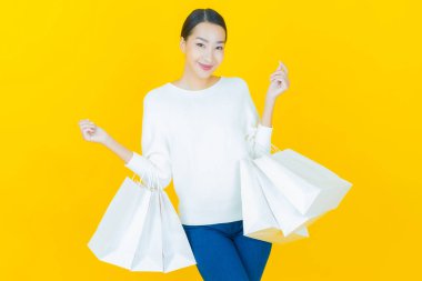 Portre güzel Asyalı kadın tebessümü ile renk arka planında alışveriş torbası