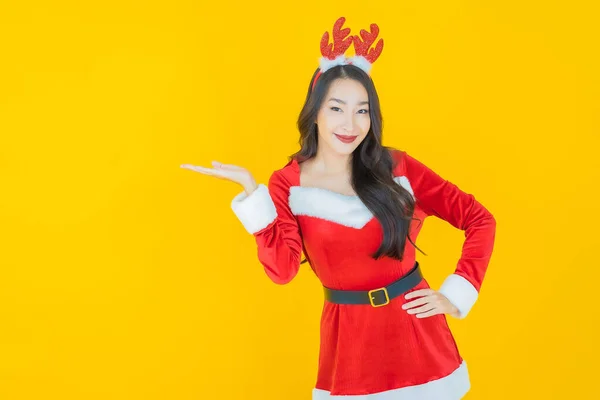 穿着黄色背景圣诞老人服装的美丽的亚洲女人 — 图库照片