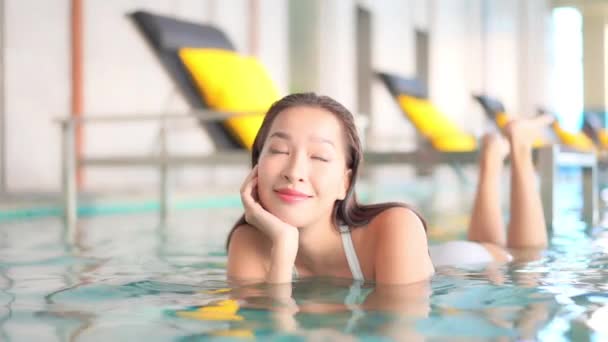 休暇中にホテルのプールでリラックスした美しいアジアの女性の映像 — ストック動画