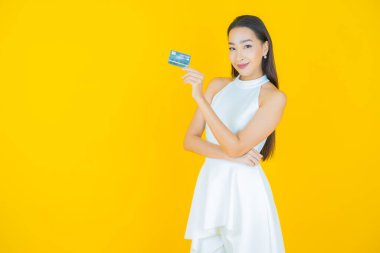 Güzel bir Asyalı kadının portresi. Renkli kredi kartıyla gülüyor.