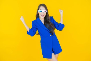 Sarı arka planda 3D gözlüklü güzel Asyalı kadın portresi.