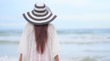 Yaz tatilinde deniz kıyısındaki Asyalı kadının görüntüleri.