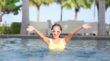 Otelde yüzme havuzunda dinlenen Asyalı güzel bir kadının görüntüsü.