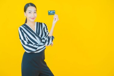 Güzel bir Asyalı kadının portresi. Renkli kredi kartıyla gülüyor.