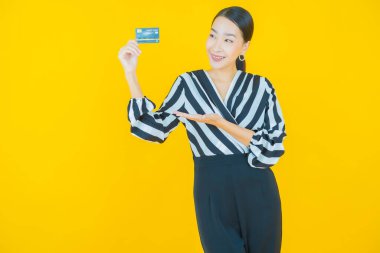 Güzel bir Asyalı kadının portresi. Renkli kredi kartıyla gülüyor.