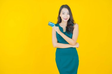 Güzel bir Asyalı kadının portresi. Renkli kredi kartıyla gülüyor.