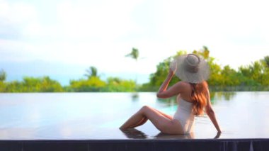 Otelde yüzme havuzunda dinlenen Asyalı güzel bir kadının görüntüsü.