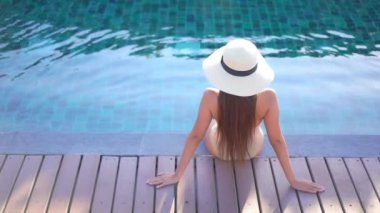 Otelde yüzme havuzunda dinlenen Asyalı güzel bir kadının görüntüsü.