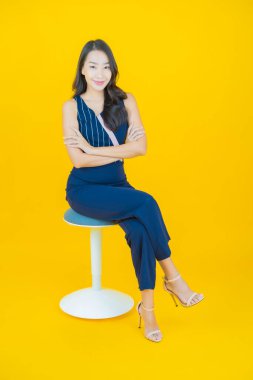 Portre güzel Asyalı kadın gülümsüyor. Renkli arka planda hareket var.