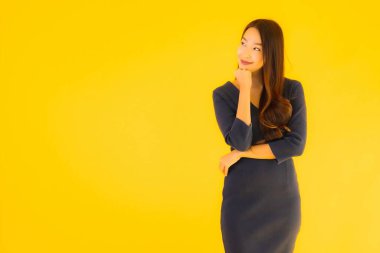 İzole edilmiş sarı arka planda hareketli güzel Asyalı kadın portresi.