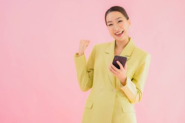 Güzel Asyalı iş kadını portresi. Arka planda kahve fincanı ve akıllı cep telefonu kullanıyor.