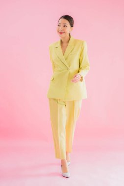 Portre güzel Asyalı genç iş kadını pembe arka planda gülümsüyor