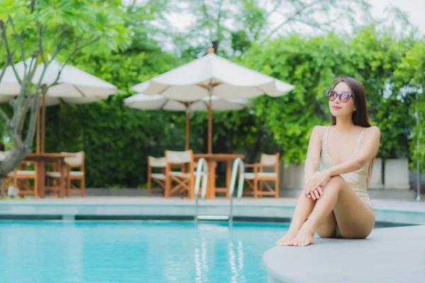 ポートレート美しい若いアジアの女性はレジャー休暇のためのホテルリゾートで屋外スイミングプールの周りの笑顔をリラックス — ストック写真