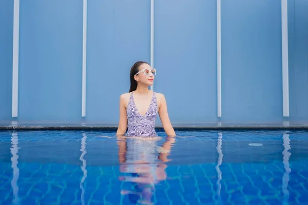 亚洲年轻貌美的女子在户外游泳池边悠闲地笑着度假 — 图库照片