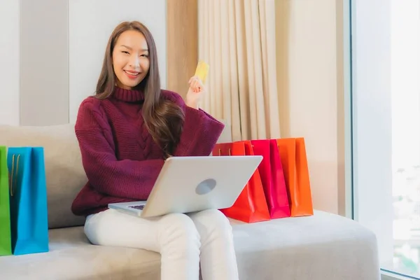 아름다운 아시아 여성이 소파에서 온라인 쇼핑을 카드가 컴퓨터 노트북을 사용하는 — 스톡 사진