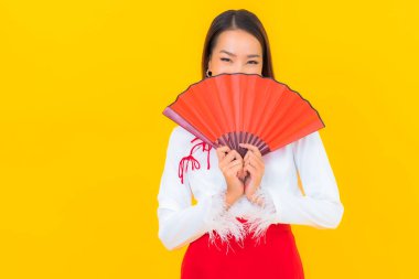 Sarı arka planda kırmızı zarflı güzel Asyalı kadın portresi.