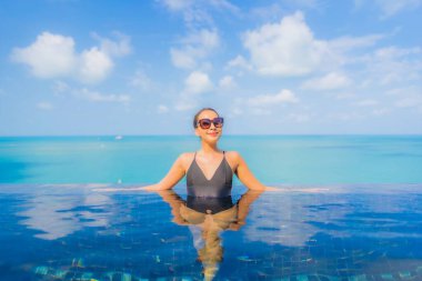 Güzel bir Asyalı kadın portresi. Rahatlayın. Okyanus manzaralı, tatil köyündeki yüzme havuzunda rahatlayın.