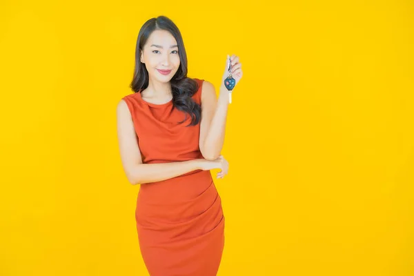 Asyalı Güzel Bir Kadının Portresi Sarı Arka Planda Araba Anahtarıyla — Stok fotoğraf