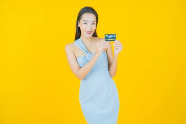 Güzel bir Asyalı kadının portresi. Renkli kredi kartıyla gülüyor.