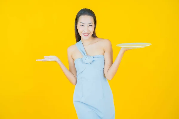 肖像画美しい若いアジアの女性の笑顔とともに空のプレート料理上の色の背景 — ストック写真