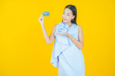 Güzel bir Asyalı kadının portresi. Renkli kredi kartıyla gülüyor.