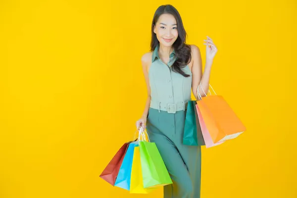 아름다운 아시아 여성의 초상화 배경에 쇼핑백을 미소짓는 — 스톡 사진