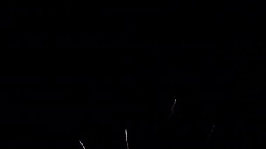 Gece gökyüzünde patlayan havai fişeklerin yakın çekim görüntüleri.