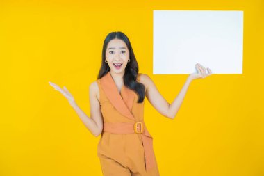 Renkli arka planda boş beyaz ilan panosu olan güzel Asyalı kadın portresi