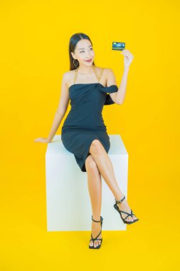 Güzel bir Asyalı kadının portresi. Renkli kredi kartıyla gülüyor.