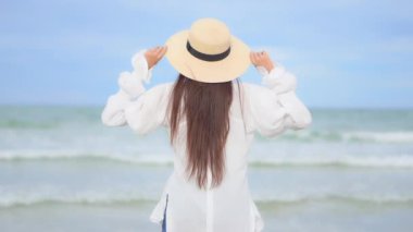 Yaz tatilinde deniz kıyısındaki Asyalı kadının görüntüleri.